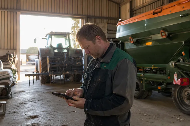 Landwirt erfasst nach einer Düngung Schlagdaten auf einem Tablet